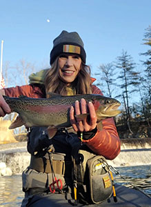 Fishing in river holding rainbow trout fish.